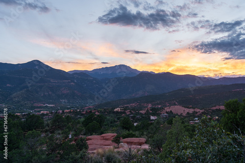 A colorful sunset over Pike's Peak and other blue mountains and red rocks on a fall/summer evening, as viewed from Garden of the Gods in Colorado Springs, CO