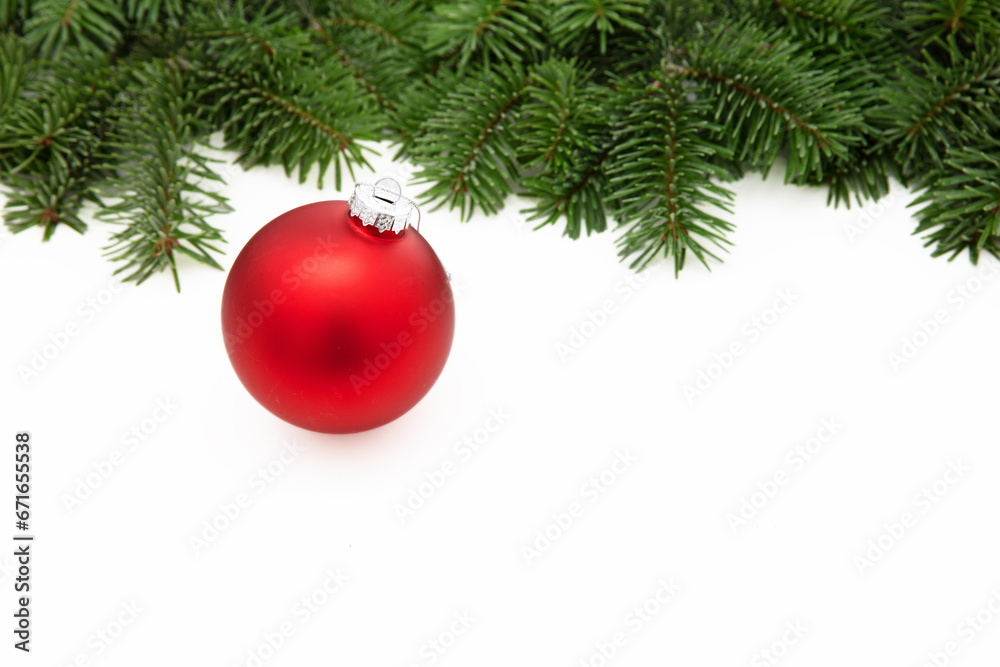 Christmas greeting card, red Xmas bauble on fir twig isolated on white background