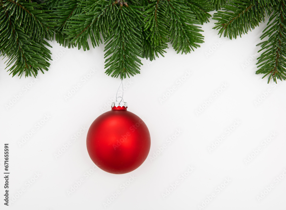 Christmas season greeting card template, red Xmas bauble hanging on fir twig isolated on white background, 