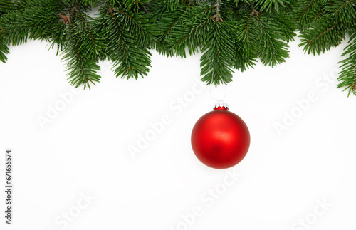 Christmas season greeting card template, red Xmas bauble hanging on fir twig isolated on white background, 