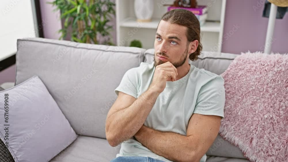 Young hispanic man sitting on sofa thinking at home Young hispanic man sitting on sofa thinking at home