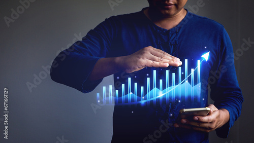 Businessman showing business growth graph from mobile phone display.