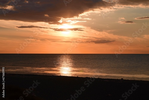 Dramatic sea sunrise. Burning sky and shining golden waves. © oleksandr