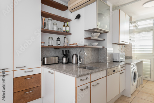 Kitchen with cabinets, sink and washing machine in flat