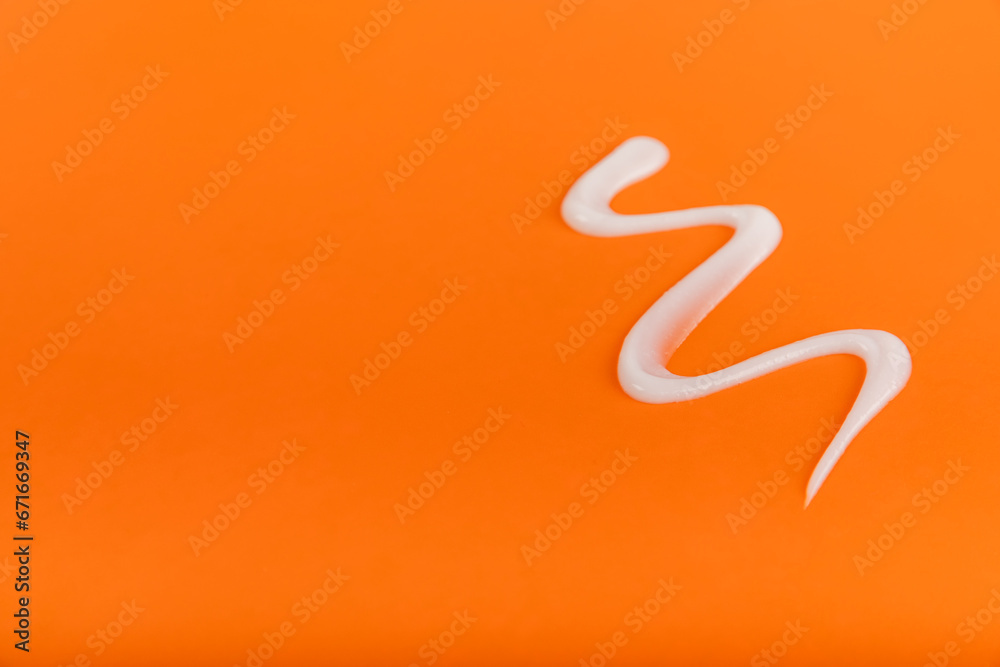 Fototapeta premium Sunscreen on an orange background. SPF cream. Sun protection. UV protection. Summer. The concept of rest and vacation. Summer mood. Design. MOCKUP. Shopping concept.