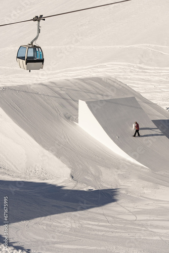 Snowpark Shaper shaping a kicker with a shapetool . Winter dolomites in Italy. Madonna di Madonna di Campiglio and ursus snowpark in Val Rendena dolomites trentino Italy. photo