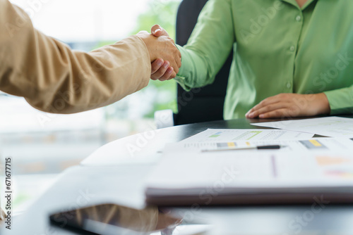 Business People shaking hands with unrecognizable colleague during successful making a deal meeting in the boardroom.