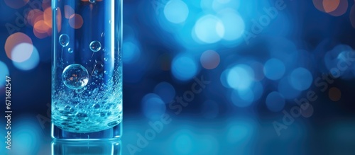Human embryo created through artificial insemination or IVF in a glass tube on a blue laboratory backdrop representing the idea of human cloning photo