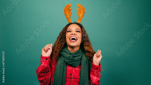 Fotografija Excited young woman jumps and dances excited for Christmas, studio