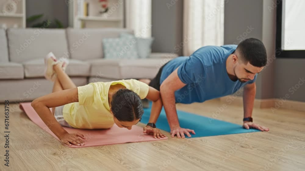 Beautiful couple showcasing power and love, training together with indoor push up workout at home Beautiful couple showcasing power and love, training together with indoor push up workout at home