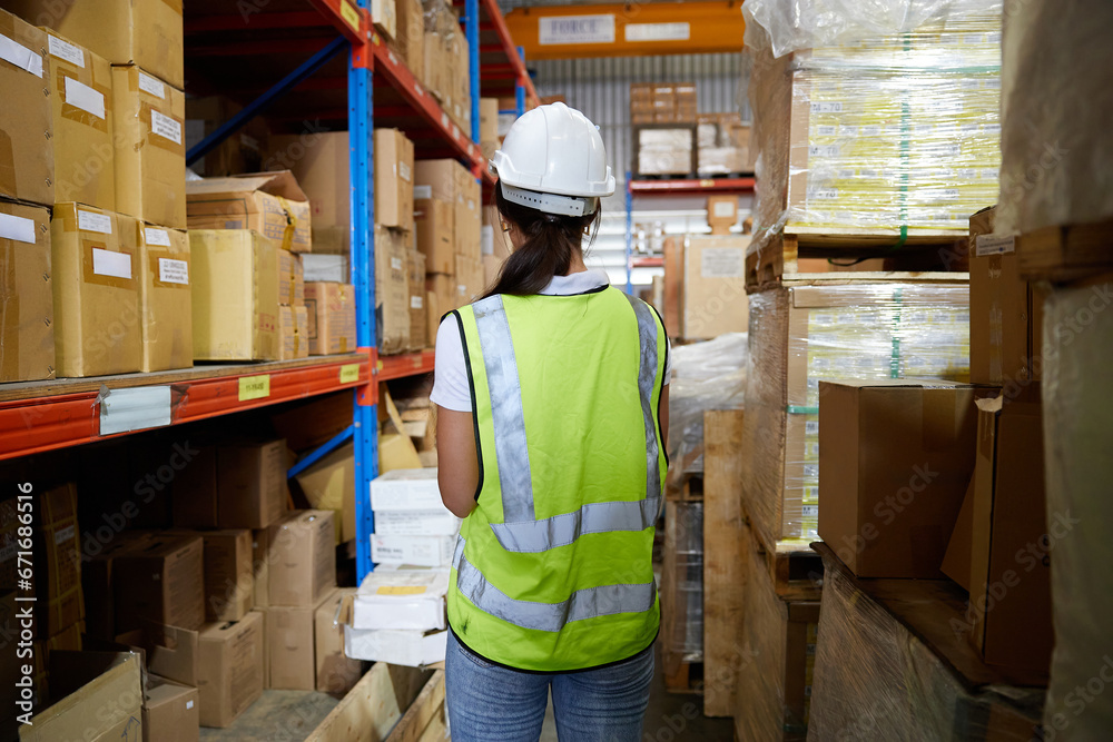 back view worker looking at cardboard box on shelf in warehouse storage back view worker looking at cardboard box on shelf in warehouse storage