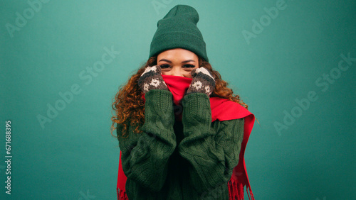 Freezing cold woman bundles up against the cold, huddles in warm scarf, studio