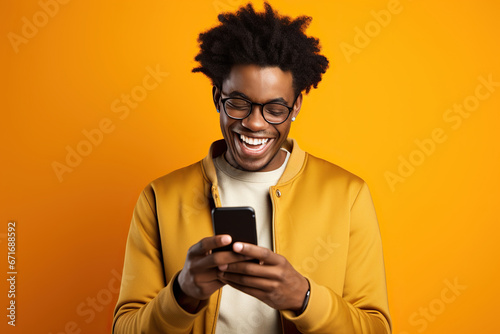 The excitement and joy of an African young man who is celebrating with his phone in his hand. photo