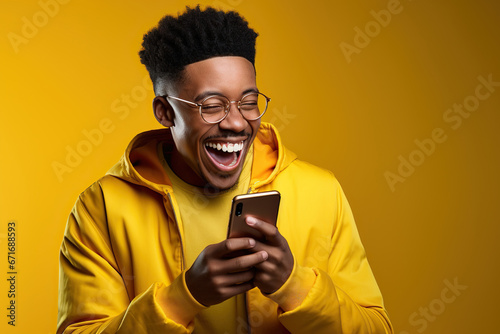 The excitement and joy of an African young man who is celebrating with his phone in his hand.