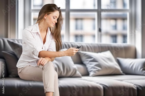 Happy young woman relax at home texting on smartphone Free Download Happy young woman relax at home texting on smartphone - GFXLoad