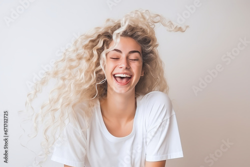 Innocent woman shaking her curly blonde hair photo