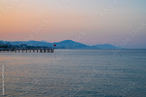 Fototapeta Naklejka Na Ścianę i Meble -  Beautiful sunrise scene on Alanya beach with view to famous Alanya island, in Turkey