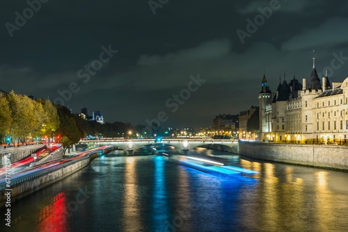 Paris, France. River Seine at night. Bridge au Change and City Palace and prison on the right. Trace of traffic lights. photo