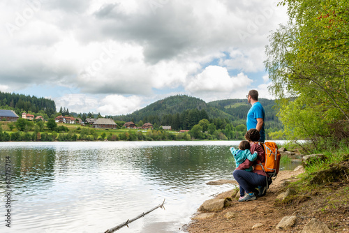 Family looking at Schluchsee village in Black Forest (Germany) from the other side of the lake.