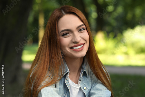 Portrait of happy young woman in casual clothes outdoors. Attractive lady smiling and looking into camera