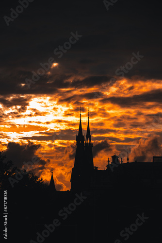 Stormy and dramatic sunset and silhouettes of the cathedral spire in Amsterdam, Netherlands © Fauren