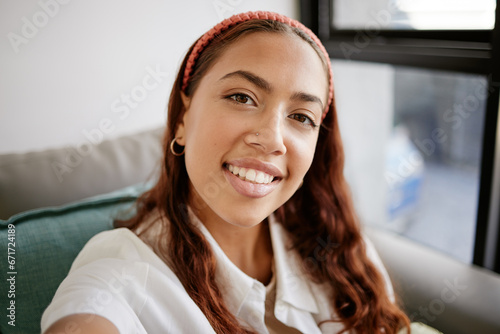 Relax, home and selfie of latina woman on the sofa enjoying free time, holiday and weekend. Beauty, smile and face portrait of young female in city apartment chilling, relaxing and happy on vacation #671724189