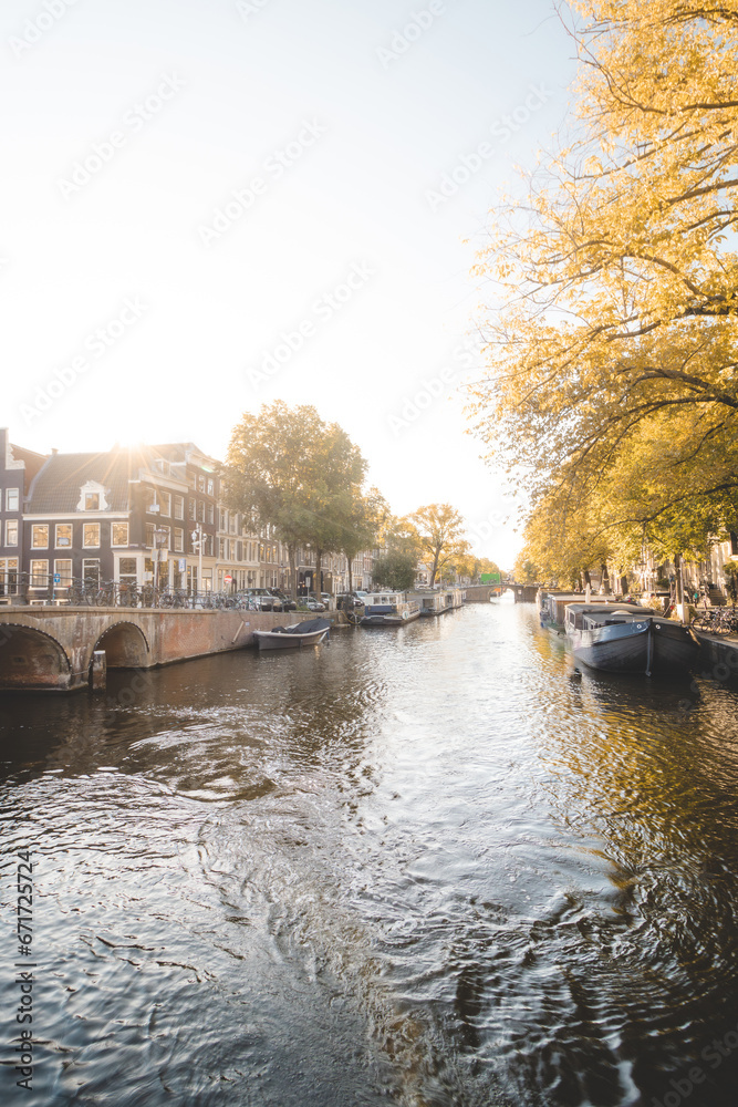 Sunset illuminates a water canal and adjacent buildings in the capital city of Amsterdam, the Netherlands. Venice of the North