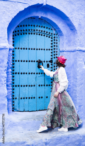tourist knocking on the blue streets of Chefchaouen Morocco © Agata Kadar