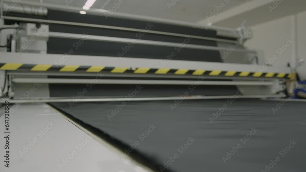 Textile factory. spinning of the fabric roll. Machine for cutting rolls of fabric for garment production. Clothing factory. Modern machines for fabric. Working with fabric. Crisis of overproduction Textile factory. spinning of the fabric roll. Machine for cutting rolls of fabric for garment production. Clothing factory. Modern machines for fabric. Working with fabric. Crisis of overproduction