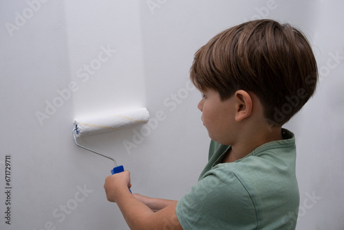 children paint the wall with a roller. teenagers spend time together helping to make repairs.
