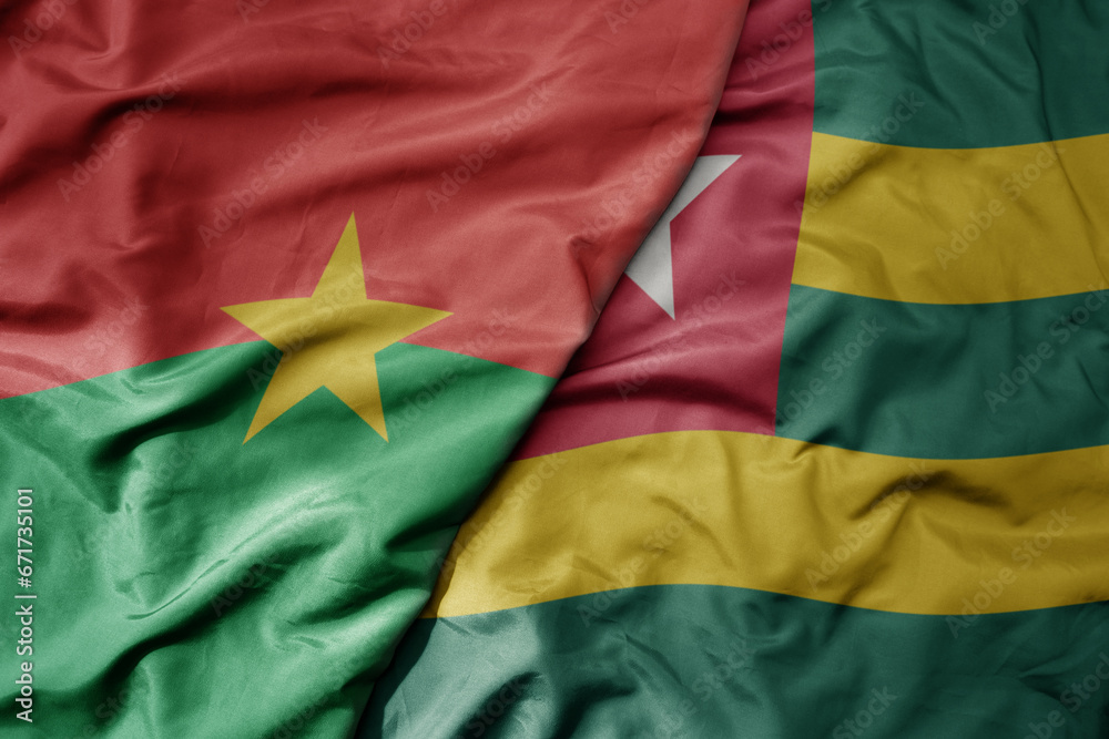 big waving national colorful flag of burkina faso and national flag of togo .