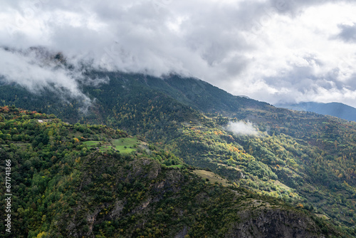 Lush slopes of a mountain illuminated by a sunbeam on a cloudy autumn day in valle de chistau  spanish pyrenees. 