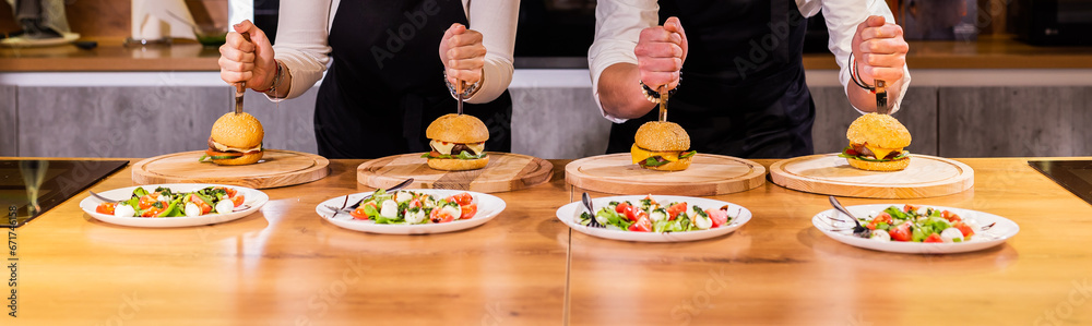 Beef burgers and salad on wooden table. Fat unhealthy food close-up Beef burgers and salad on wooden table. Fat unhealthy food close-up