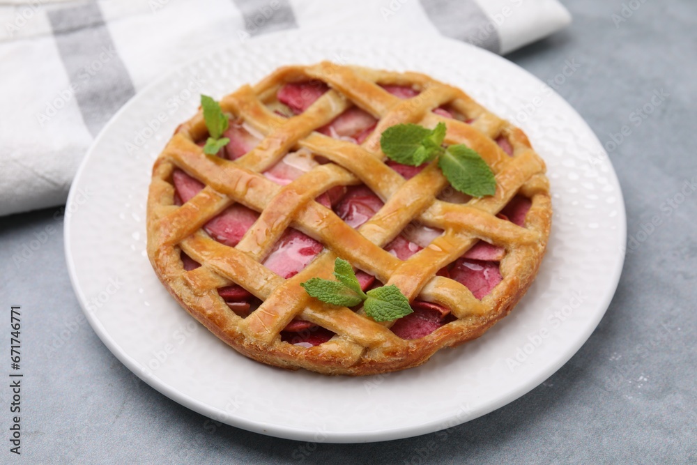 Delicious apple pie with mint on grey table, closeup Delicious apple pie with mint on grey table, closeup
