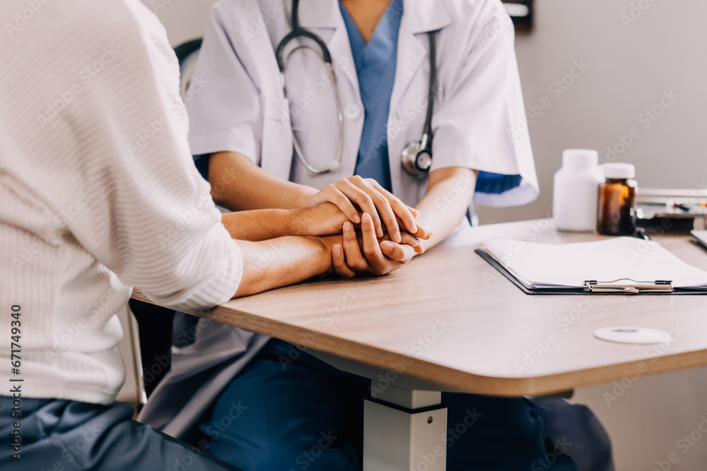 Doctor giving hope. Close up shot of young female physician leaning forward to smiling elderly lady patient holding her hand in palms. Woman caretaker in white coat supporting encouraging old person