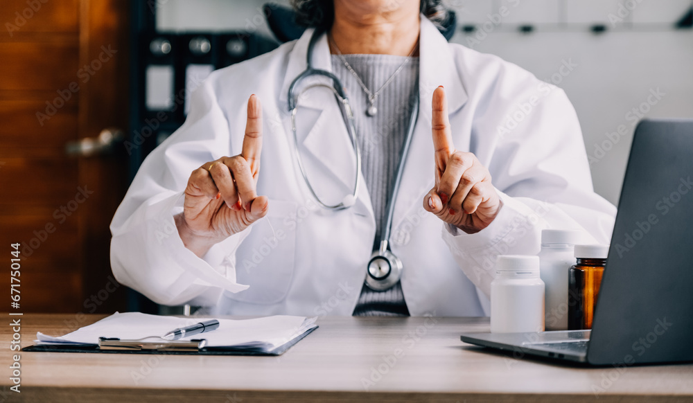 Shot of attractive female doctor working with her computer in medical consultation.