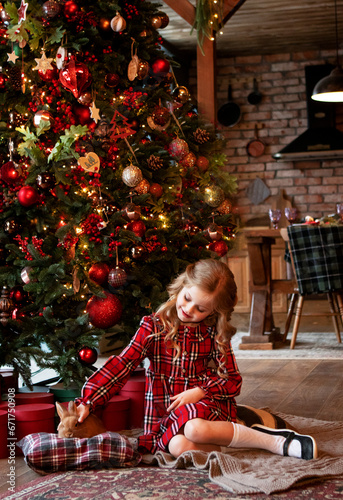 girl with a rabbit at home by the Christmas tree. Christmas concept