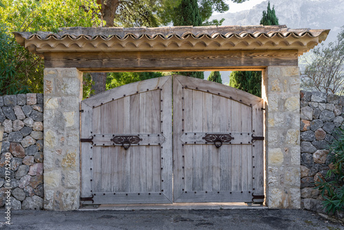 Obraz na plátně Semicircular wooden gates with forged door handles and forged hinges