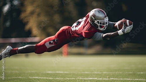 American football player making a diving catch, athleticism and intensity of the game photo
