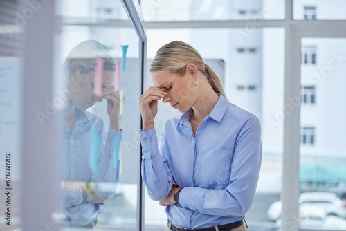 Sad, burnout and worried business woman with a work stress headache at an office. Corporate finance manager working overtime with anxiety about an accounting audit, financial tax and job project