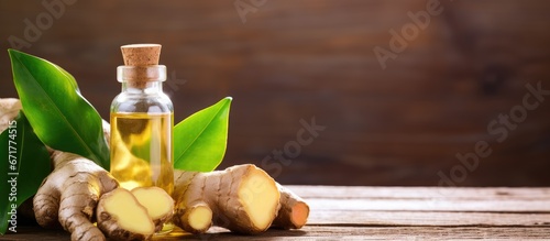 The rhizome of the ginger plant soaked in essential oil placed on a wooden table photo