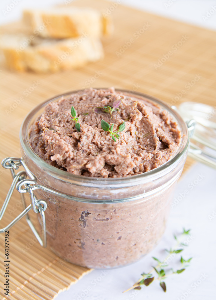 Close up of Vegan spread made with lentils and nuts on a rustic bread slice and in a glass jar, decorated with rosemary. Vegan dipping. Close up of Vegan spread made with lentils and nuts on a rustic bread slice and in a glass jar, decorated with rosemary. Vegan dipping.