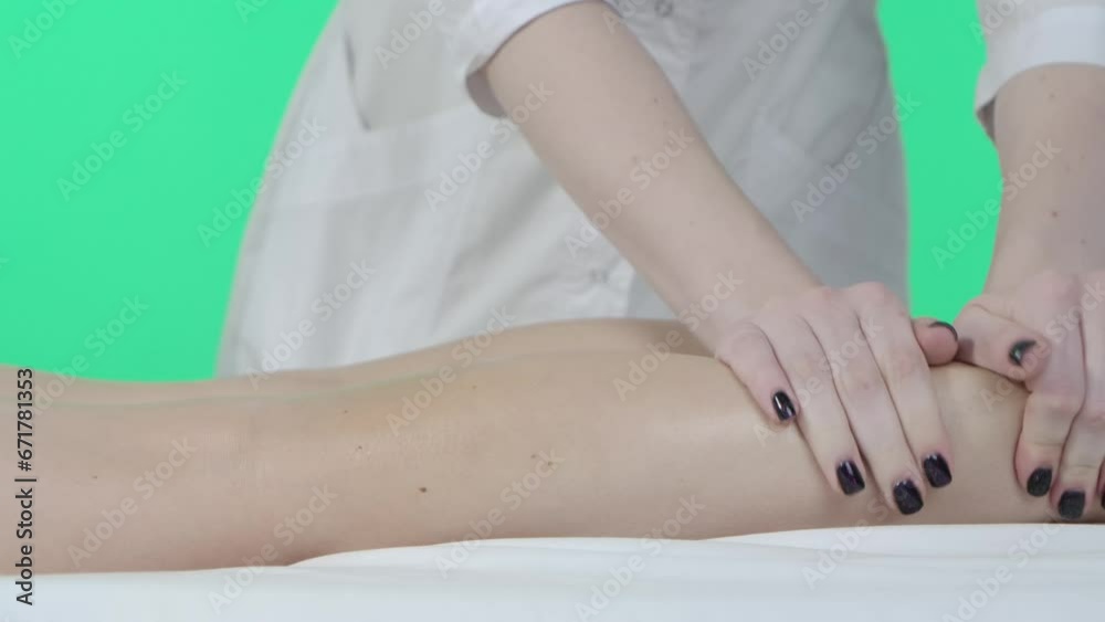 Beauty clinic room, woman on massage table, Chroma key green screen background, therapist doing calves massage with oil, close up. Advertising area, workspace mockup