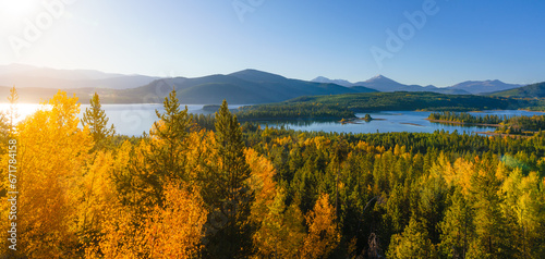 Fototapeta Naklejka Na Ścianę i Meble -  Sunrise flare autumn aspen trees, mountains, and lake landscape in Colorado 