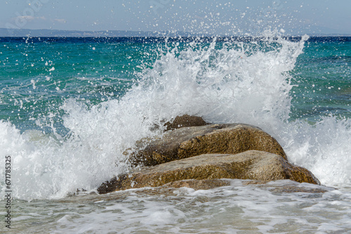 Fototapeta Naklejka Na Ścianę i Meble -  frothy wave crashes against  coastal rock