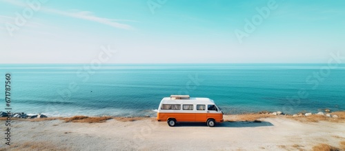 Vanlife freedom Orange camper van by the blue ocean summer wanderlust mobile tourism roadtrip destination drone view