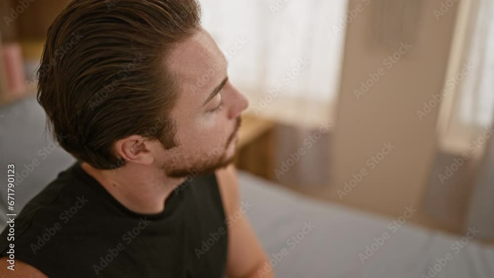 Young hispanic man lying on bed sleeping waking up at bedroom Young hispanic man lying on bed sleeping waking up at bedroom