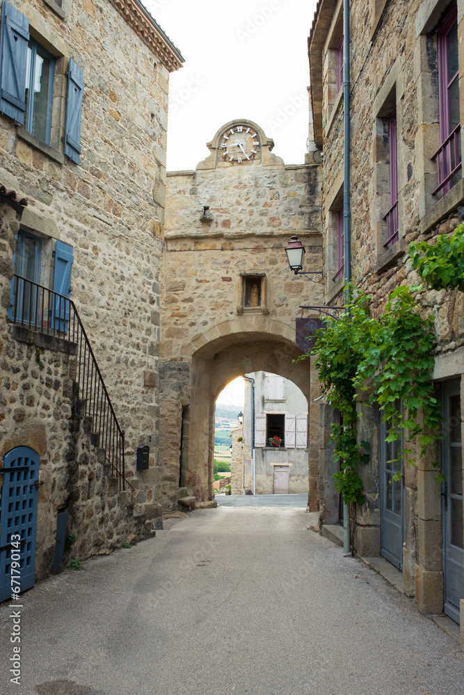 Fototapeta premium The clock arch at the main entrance of the charming medieval village of Montpeyroux, Auvergne, France.