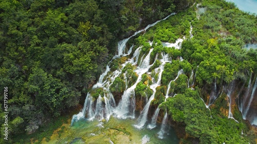 Summer forest and mountain landscape with streams of water and waterfalls. Cascades flow among lush greenery.