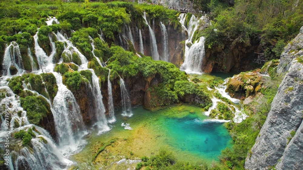 Obraz premium Summer forest and mountain landscape with streams of water and waterfalls. Cascades flow among lush greenery.